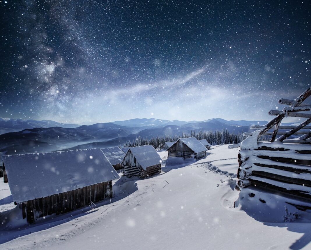 Night with stars. Christmas landscape. Wooden house in the mountain village. Night landscape in winter0