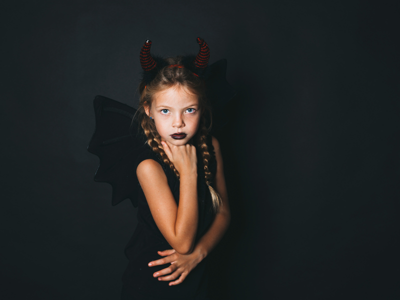 beautiful, blond girl is dressed as halloween devil with red horns and wings0