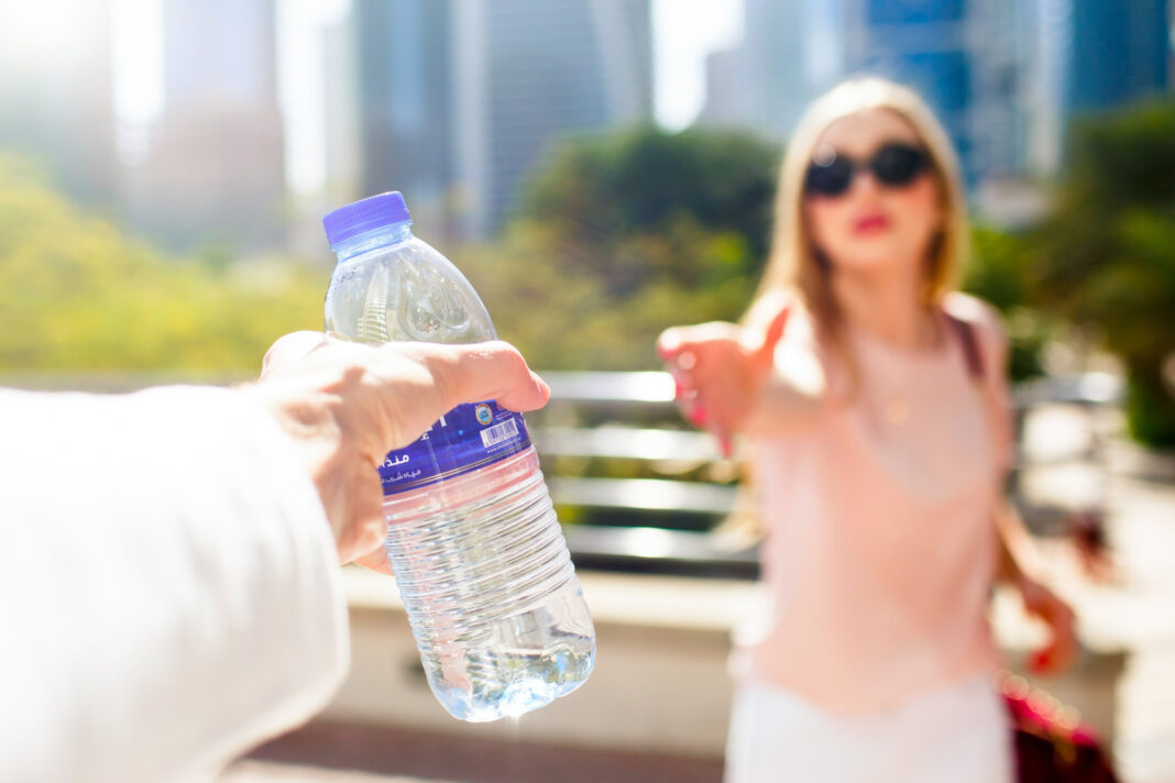 girl-reaches-her-hand-out-take-bottle-water-from-man-s-hand0
