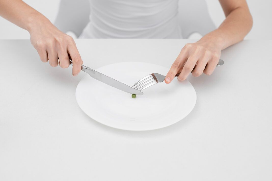 young-woman-with-eating-disorder-wanting-eat-pea0