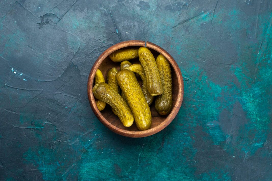 top-view-salty-pickles-inside-round-brown-pot-dark-blue-surface0