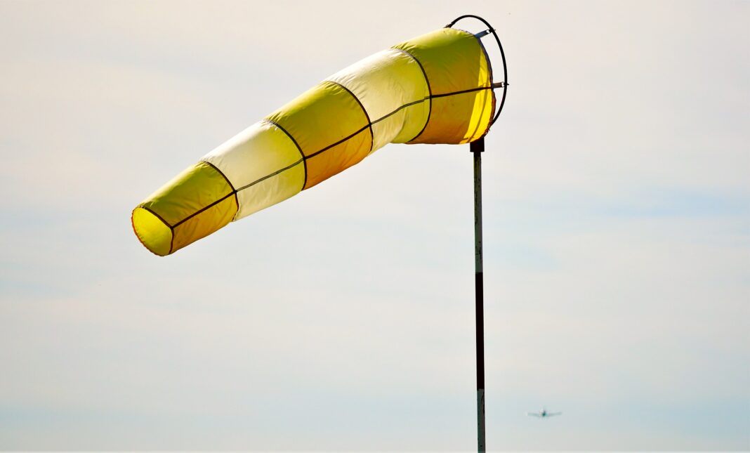Closeup of a yellow and white windsock floating in the air during daylight0